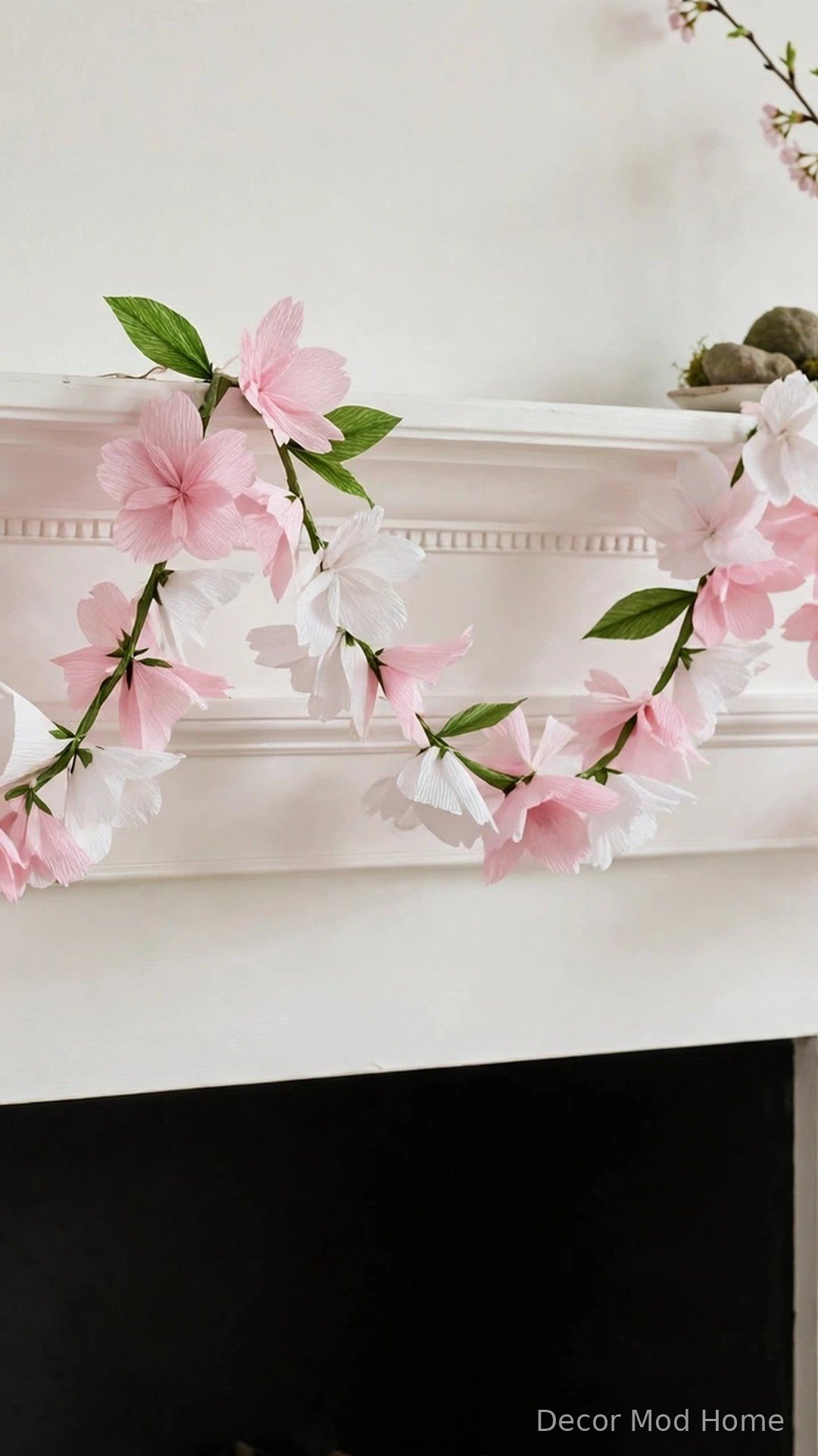 Handmade pink and white crepe-paper cherry blossom garland on a fireplace mantel